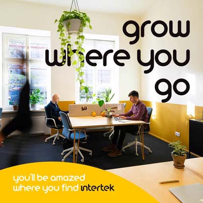 An office environment with two individuals sitting at a work table.